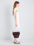 Proenza Schouler Image of model wearing Bucket bag in Raffia in Plum
