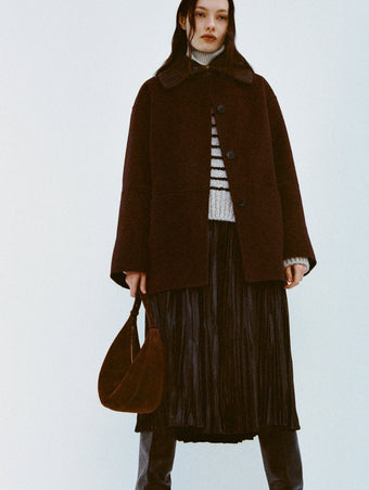 Image of model wearing Lisa Coat in Double Face Wool in Hickory and Rosalyn Skirt in Faux Leather in Black and black boots on a white background