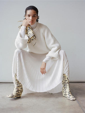 Proenza Schouler Front full length image of model sitting wearing Luiza Skirt in Sunburst Rib in White