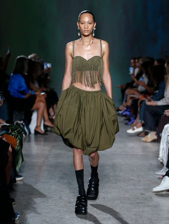 Selena Forrest wearing khaki top and skirt