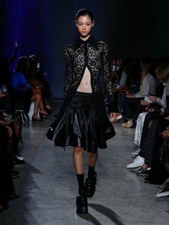 model wearing black lace top and skirt