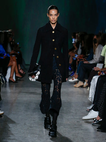 model wearing black jacket and lace pants