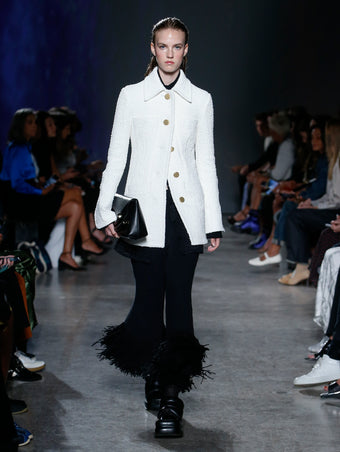 model wearing white jacket and black fringe pants