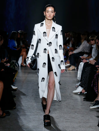 model wearing white coat with embellishments