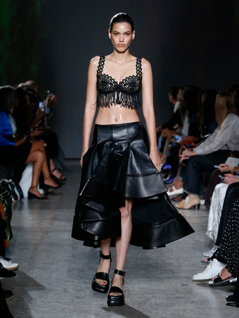 model wearing lace bra top with black leather skirt