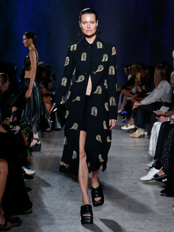 Shalom Harlow wearing black coat with embellishments