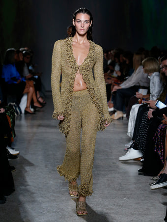 Vittoria Ceretti wearing gold top and pant