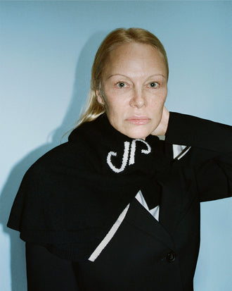 Cropped image of Pamela Anderson wrapped in Stella Monogram Sweater in Cashmere Jacquard in black