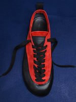 Proenza Schouler editorial image of Arcadia Sneakers in red with black laces on a blue background. 