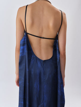 Proenza Schouler Back editorial image of model wearing Wilma Dress in Double Printed Silk Twill in Cobalt Multi with back straps untied. 