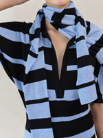 Proenza Schouler Editorial image of model wearing Solana Dress in Superfine Merino Silk in Black Multi with Gia Top in Superfine Merino Silk in Blue Multi wrapped around her neck. 