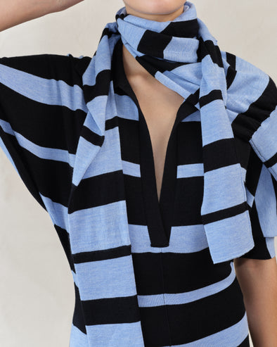 Proenza Schouler Editorial image of model wearing Solana Dress in Superfine Merino Silk in Black Multi with Gia Top in Superfine Merino Silk in Blue Multi wrapped around her neck. 