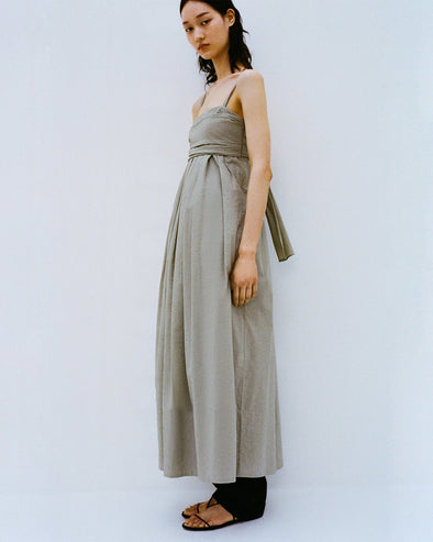 Cropped image of model standing against a white backdrop wearing the Claudine Dress in Tech Poplin in Sage