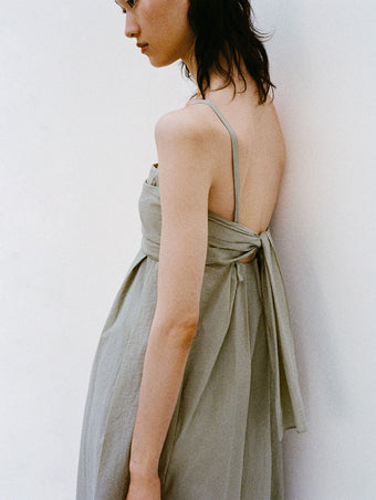 Cropped image of model standing against a white backdrop wearing the Claudine Dress in Tech Poplin in Sage
