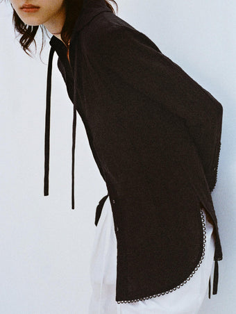 Cropped image of model leaning against white backdrop, wearing Cami Shirt in Crinkle Viscose in Black