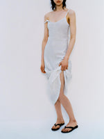 Cropped image of model standing in front of white backdrop, wearing Evelyn Dress in Crinkle Viscose in White