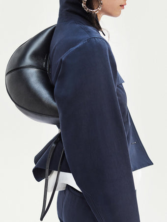 Cropped image of model standing in front of a white backdrop, wearing Thelma Jacket in Cotton Linen Suiting in Navy