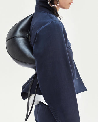 Cropped image of model standing in front of a white backdrop, wearing Thelma Jacket in Cotton Linen Suiting in Navy