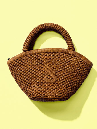 Front image of Small Chelsea Tote in Natural Raffia in Honey on a yellow backdrop