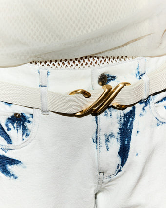 Cropped image of model in Ellsworth Jean in bleach out with Monogram Belt in Embossed Leather in cream