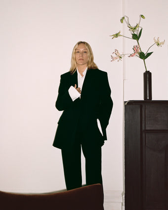 Chloe Sevigny in black wool stretch suiting jacket and trousers