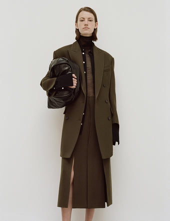 Model in Henri Coat and Diane Skirt in dark loden, carrying Large Ruched Tote In Puffy Nappa
