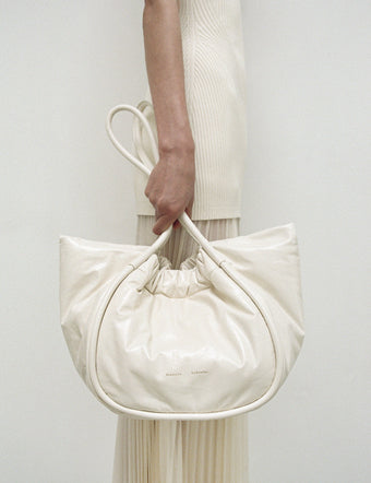 Cropped image of model holding Large Ruched Tote In Puffy Nappa in ivory