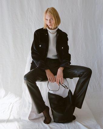 Image of model wearing Stella Jacket in Chenille Suiting in black and Lily Knit Turtleneck in Wool Blend in off white over black leather pants, carrying Spring Bag in black