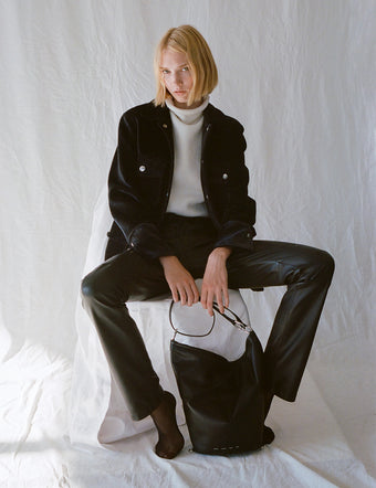 Image of model wearing Stella Jacket in Chenille Suiting in black and Lily Knit Turtleneck in Wool Blend in off white over black leather pants, carrying Spring Bag in black