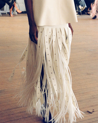 4x5 image in motion of model wearing the Effe skirt in Ivory at the SS25 runway show