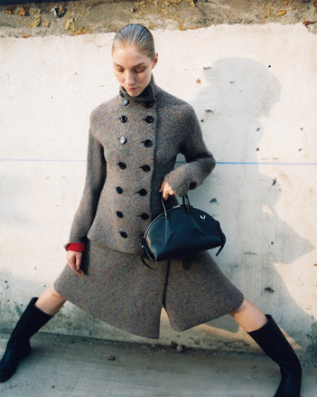 Model in the Proenza Schouler FW26 Campaign wearing Capucine knit set and holding the small Bowler bag