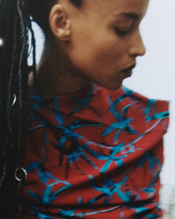 A portrait of a model in the Proenza Schouler FW26 Campaign wearing the Bodine dress in red multi