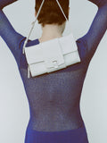 Cropped image of model wearing Anita Dress in Knit Sheer Mesh in bright blue, carrying Flip Shoulder Bag in white.