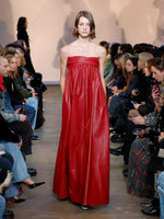 Runway image of model in Nappa Leather Strapless Dress in crimson