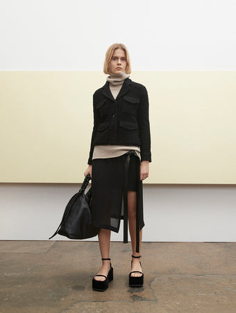 PF23 Collection Look 15: Black Bi-Stretch Tweed Jacket, Oatmeal Doubleface Cashmere Turtleneck, Black Crepe Chiffon Skirt, Black Drawstring Shoulder Bag, and Black Velvet Square Platform Sandals