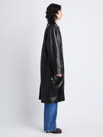 Side image of model wearing Billie Coat in Leather in black 