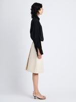 Side image of model wearing Adele Skirt In Lacquered Leather in ecru