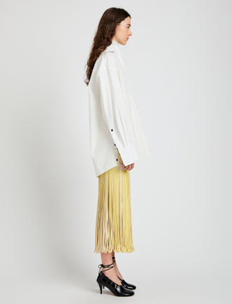 Proenza Schouler Side full length image of model wearing Veda Skirt in Faux Leather Fringe in Pale Yellow Multi