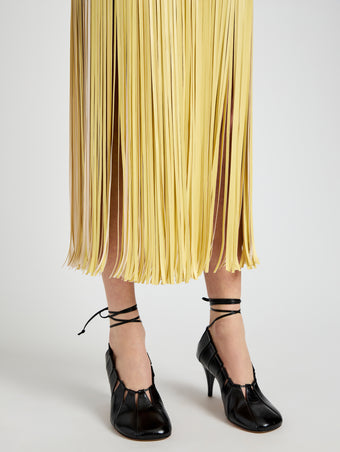 Proenza Schouler Detail image of model wearing Veda Skirt in Faux Leather Fringe in Pale Yellow Multi