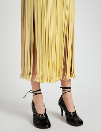 Proenza Schouler Detail image of model wearing Veda Skirt in Faux Leather Fringe in Pale Yellow Multi