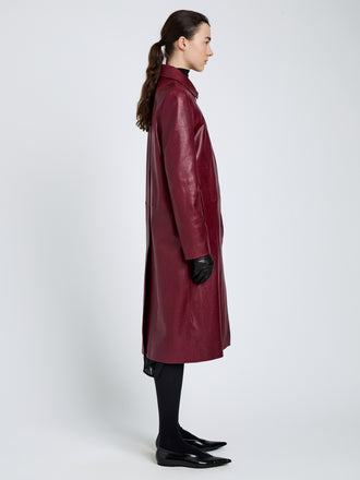Proenza Schouler Side full length image of model wearing Nissi Coat In Semigloss Leather in Burgundy