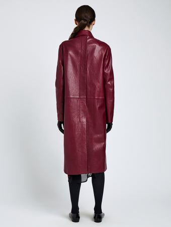 Proenza Schouler Back full length image of model wearing Nissi Coat In Semigloss Leather in Burgundy
