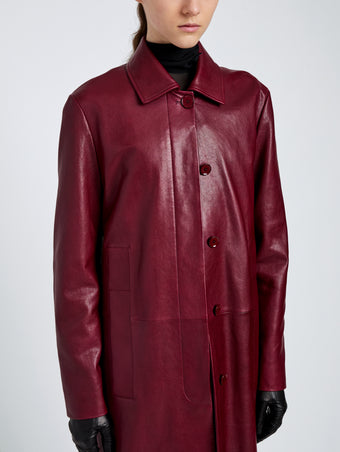 Proenza Schouler Detail image of model wearing Nissi Coat In Semigloss Leather in Burgundy