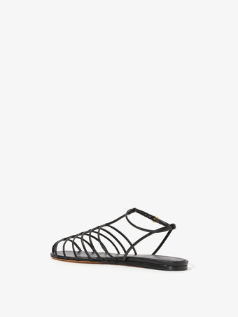 3/4 Back image of Tee Cage Flat Sandals in BLACK