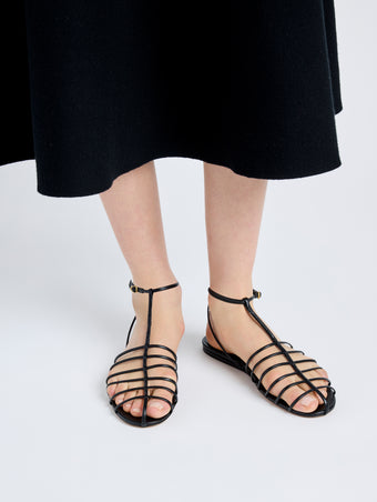 Image of model wearing Tee Cage Flat Sandals in BLACK