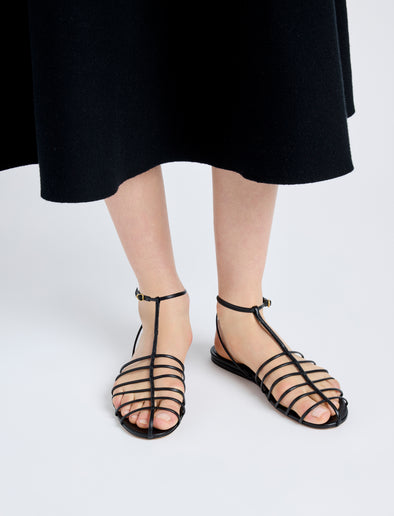 Image of model wearing Tee Cage Flat Sandals in BLACK