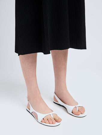 Image of model wearing Slash Flat Thong Sandals in White