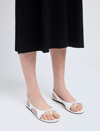 Image of model wearing Slash Flat Thong Sandals in White