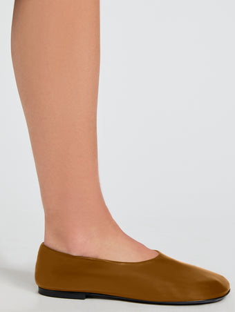 Image of model wearing Glove Slippers in Slick Nappa in Mud