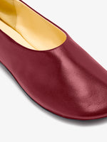 Image of model wearing Glove Slippers in Slick Nappa in Merlot